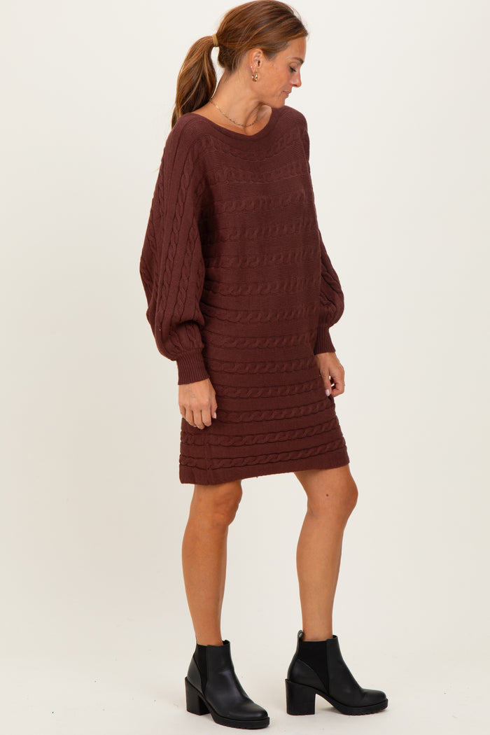 woman wearing a maroon cable knit sweater dress with long sleeves and a relaxed fit