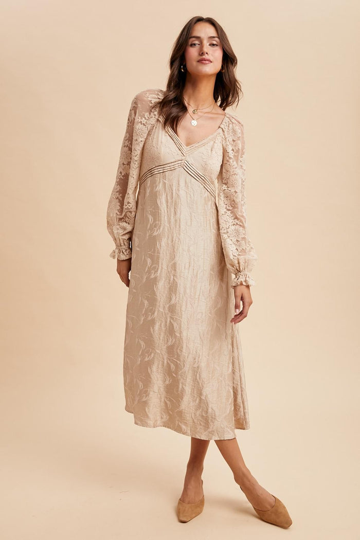 woman wearing a beige lace long sleeve dress with a v-neck and flowing silhouette, styled with beige flats