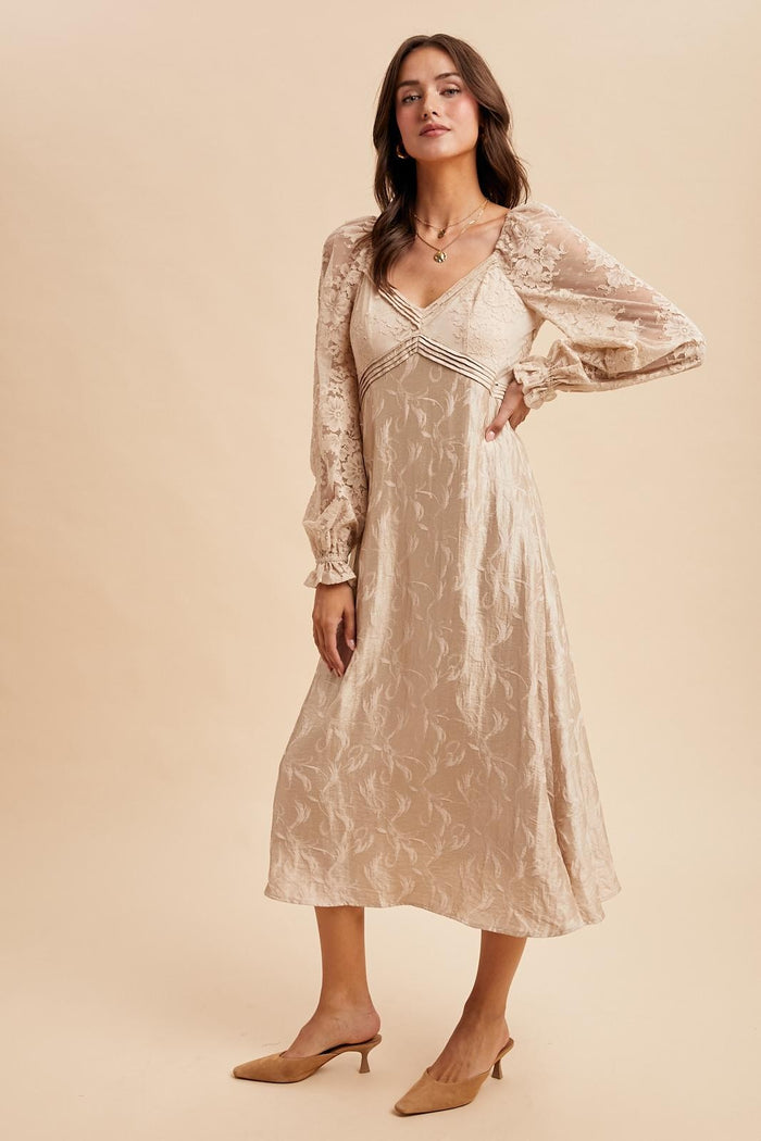 woman wearing a beige midi dress with long puff sleeves and lace details, styled with beige mules