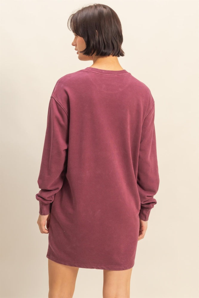 woman wearing a maroon long sleeve oversized sweatshirt dress, viewed from the back