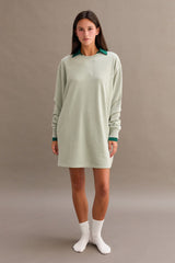 woman wearing a green oversized long sleeve dress with a dark green collar and white socks