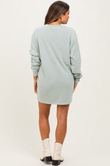 woman wearing a light green long sleeve maternity sweatshirt dress, showing the back view