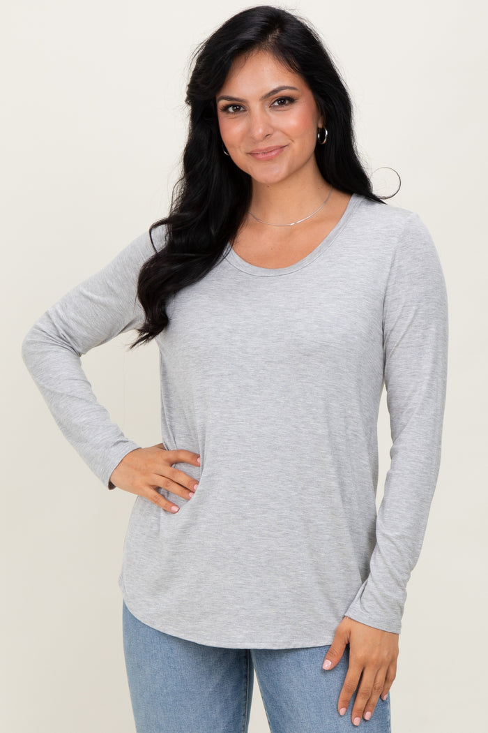 woman wearing a light gray long sleeve top with a scoop neckline and relaxed fit