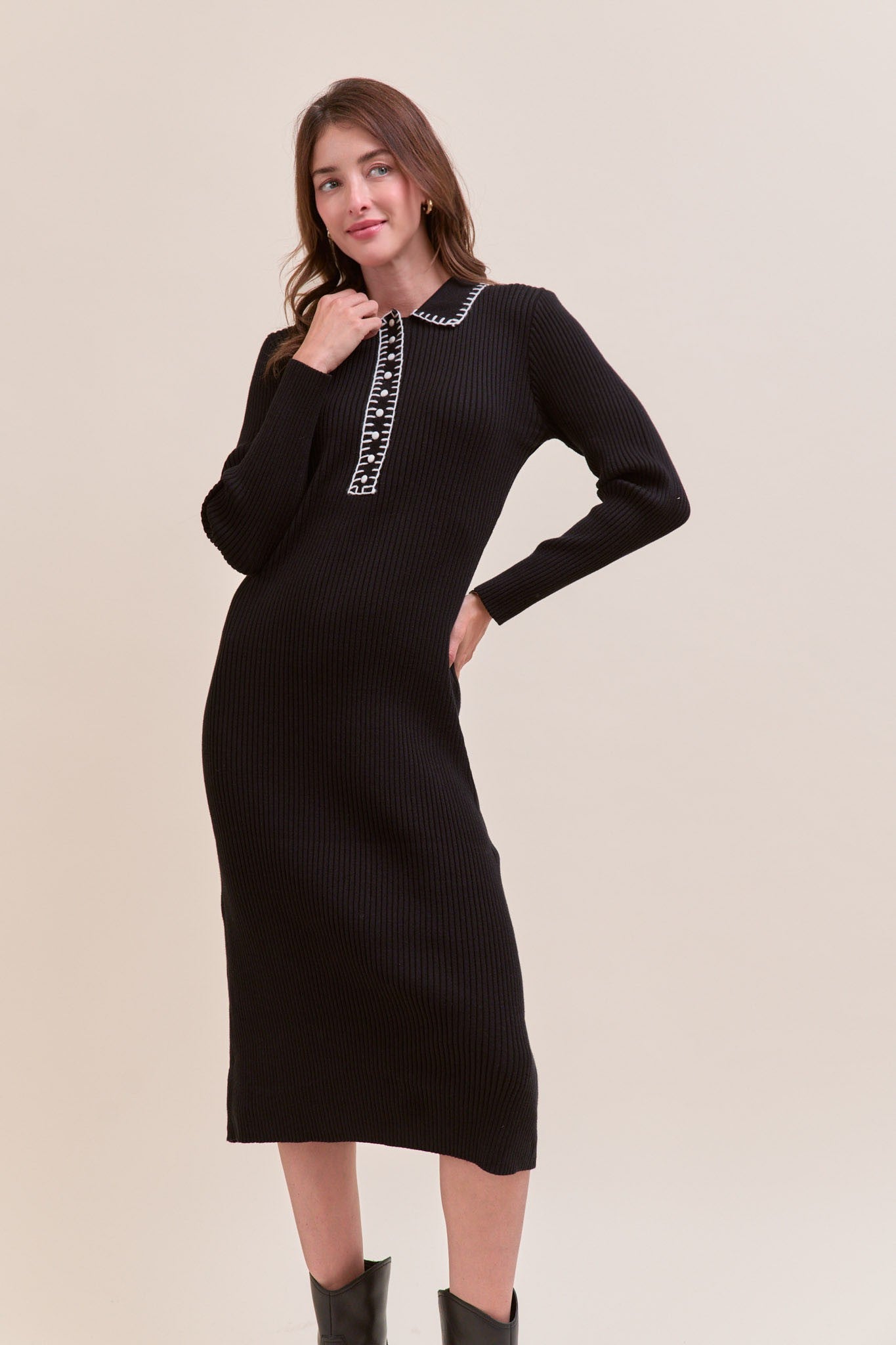 woman wearing a black ribbed midi dress with a collar and decorative stitching detail