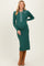 woman wearing a green ribbed maternity dress with a collar and button details, showing her baby bump