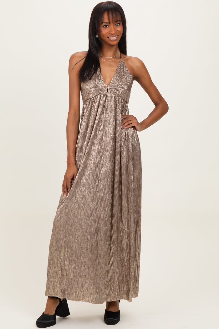 woman wearing a metallic gold halter neck maxi dress with a zip detail and pleated design