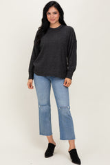 woman wearing a dark gray oversized sweater with long sleeves and distressed light wash denim jeans