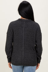 woman wearing a dark gray oversized sweater with a back seam detail and balloon sleeves