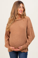 woman wearing a tan ribbed maternity sweater and holding her baby bump