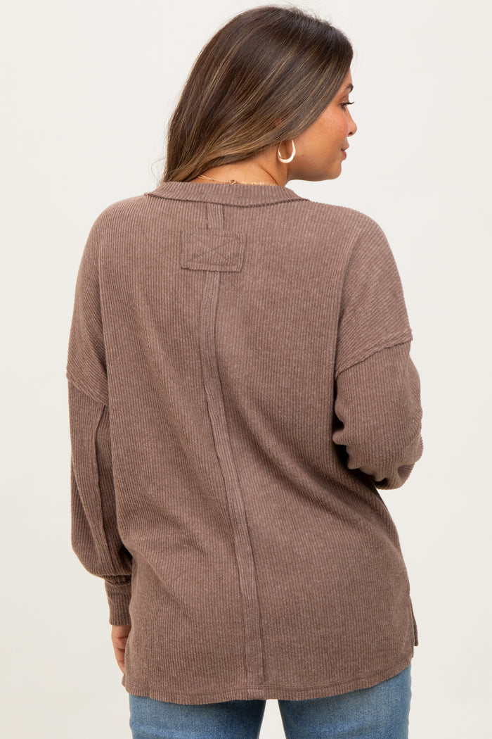 woman wearing a brown ribbed maternity top with a relaxed fit and back seam details