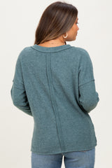 woman wearing a teal ribbed maternity sweater, view of the back, with long sleeves and a relaxed fit