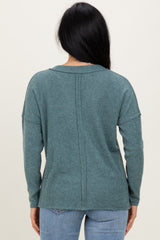 woman wearing a teal ribbed sweater with a relaxed fit and long sleeves, seen from the back
