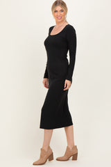 woman wearing a black long sleeve midi dress with a square neckline and styled with tan ankle boots