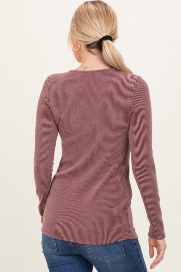 woman wearing a mauve long sleeve ribbed sweater with a fitted style and a slightly longer back hem