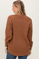 woman wearing a brown chunky knit sweater from the back with relaxed sleeves and a longer hemline