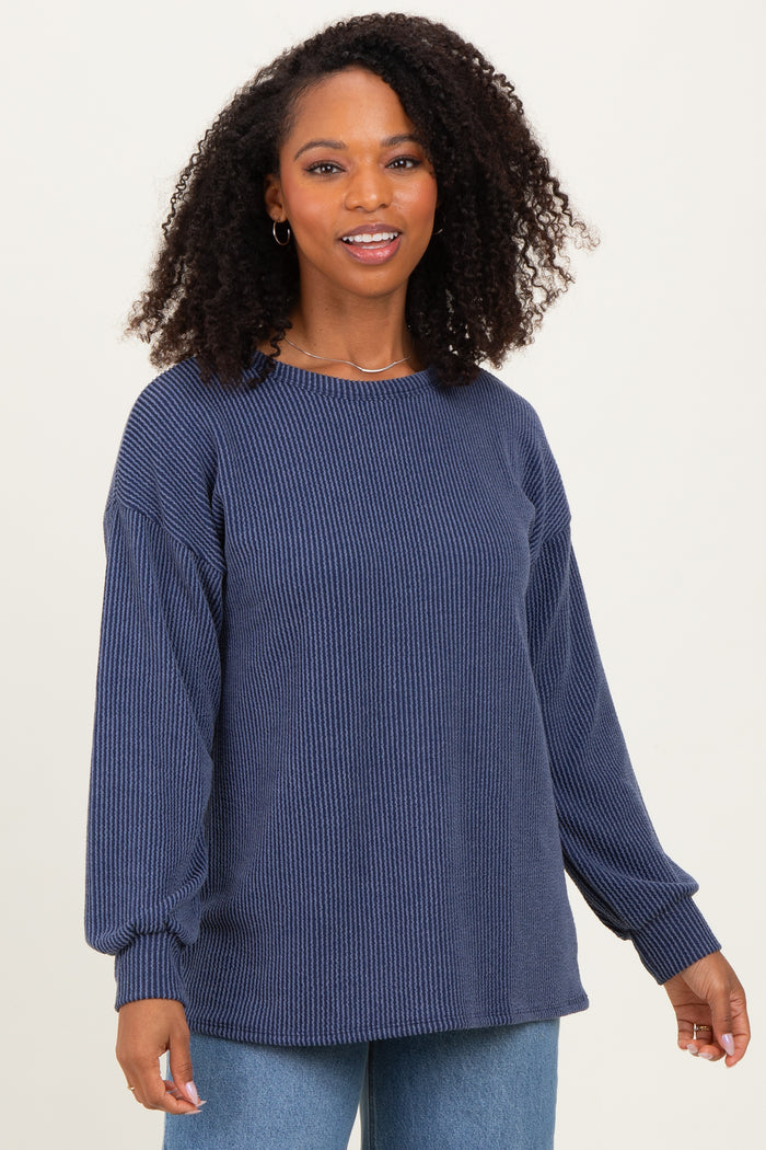 woman wearing a navy blue ribbed long sleeve sweater with a relaxed fit and balloon sleeves