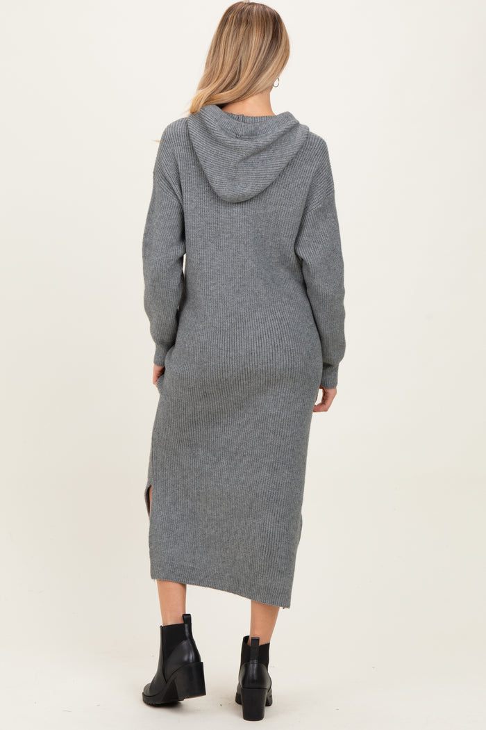 woman wearing a gray knitted maternity sweater dress with a hood and side slits, showing her baby bump from the back
