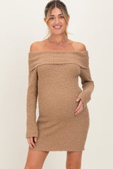 woman wearing a brown off-the-shoulder maternity dress, posing with her baby bump visible