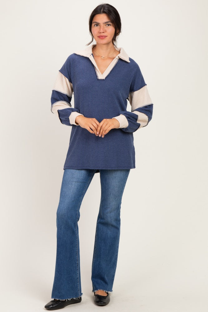 woman wearing a navy and cream striped long sleeve collared pullover sweater with a relaxed fit and flared jeans