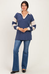 woman wearing a navy and cream striped long sleeve collared pullover sweater with a relaxed fit and flared jeans