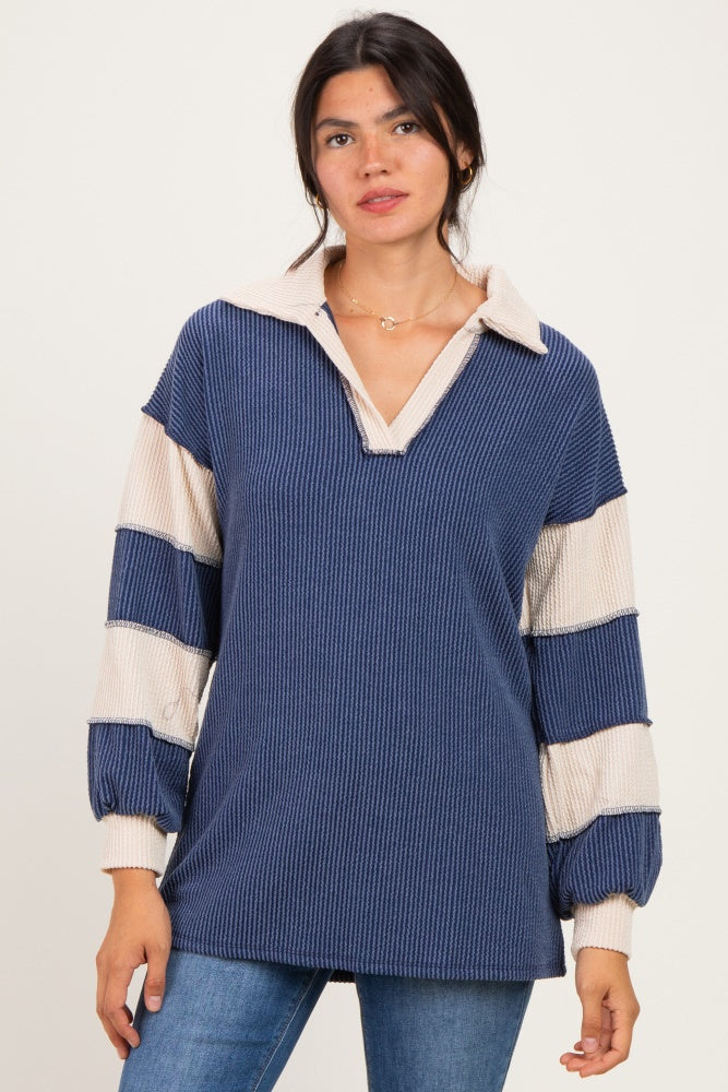 woman wearing a navy blue and cream striped pullover with a collar and puffed sleeves