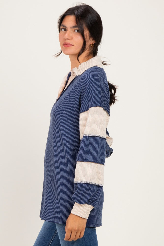 woman wearing a navy and beige striped long sleeve pullover with a collared neckline and relaxed fit