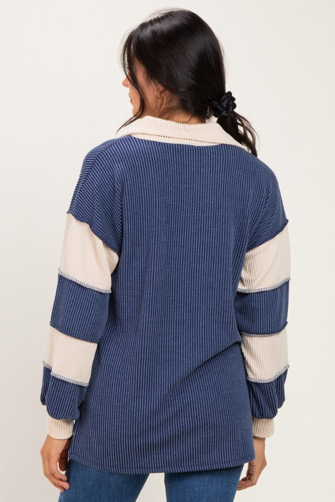 woman wearing a navy blue and cream striped oversized sweater with a collar and back seam detail
