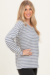 woman wearing a white and navy striped long sleeve top with a v-neck and relaxed fit