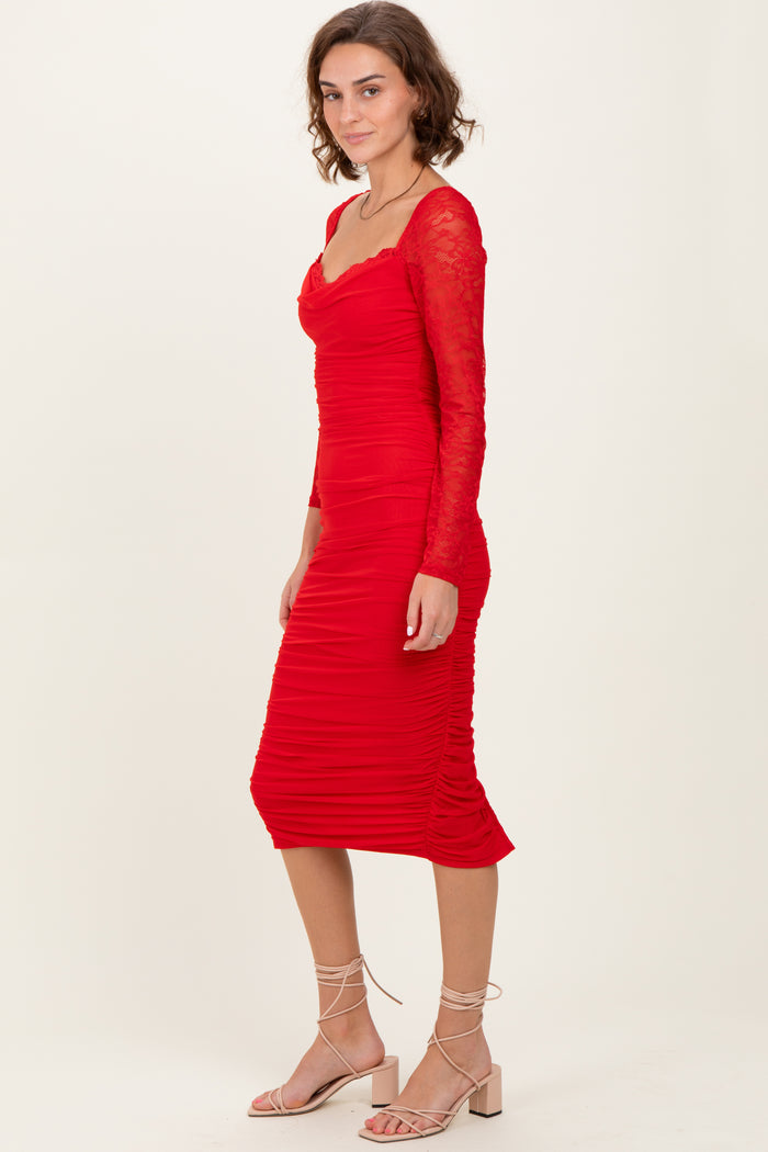 woman wearing a red ruched midi dress with long lace sleeves and a sweetheart neckline