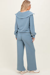 woman wearing a light blue ribbed matching lounge set with a shawl collar and wide-leg pants