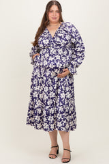 woman wearing a purple floral maternity dress with long sleeves and a tiered skirt, showing her baby bump