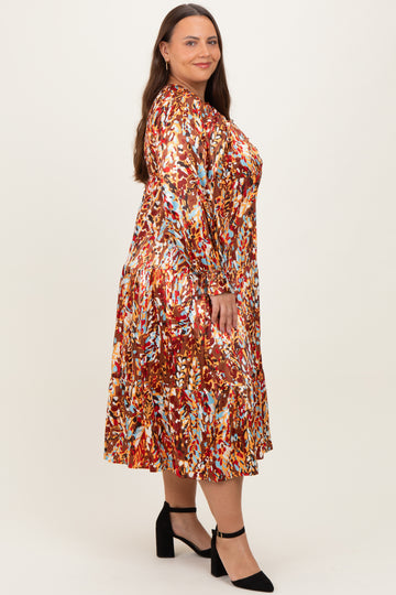 woman wearing a multicolored floral print plus size midi dress with long sleeves and a tiered hem, standing against a neutral background