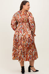 plus size woman wearing a colorful printed long sleeve maxi dress with a gathered waist and tiered skirt