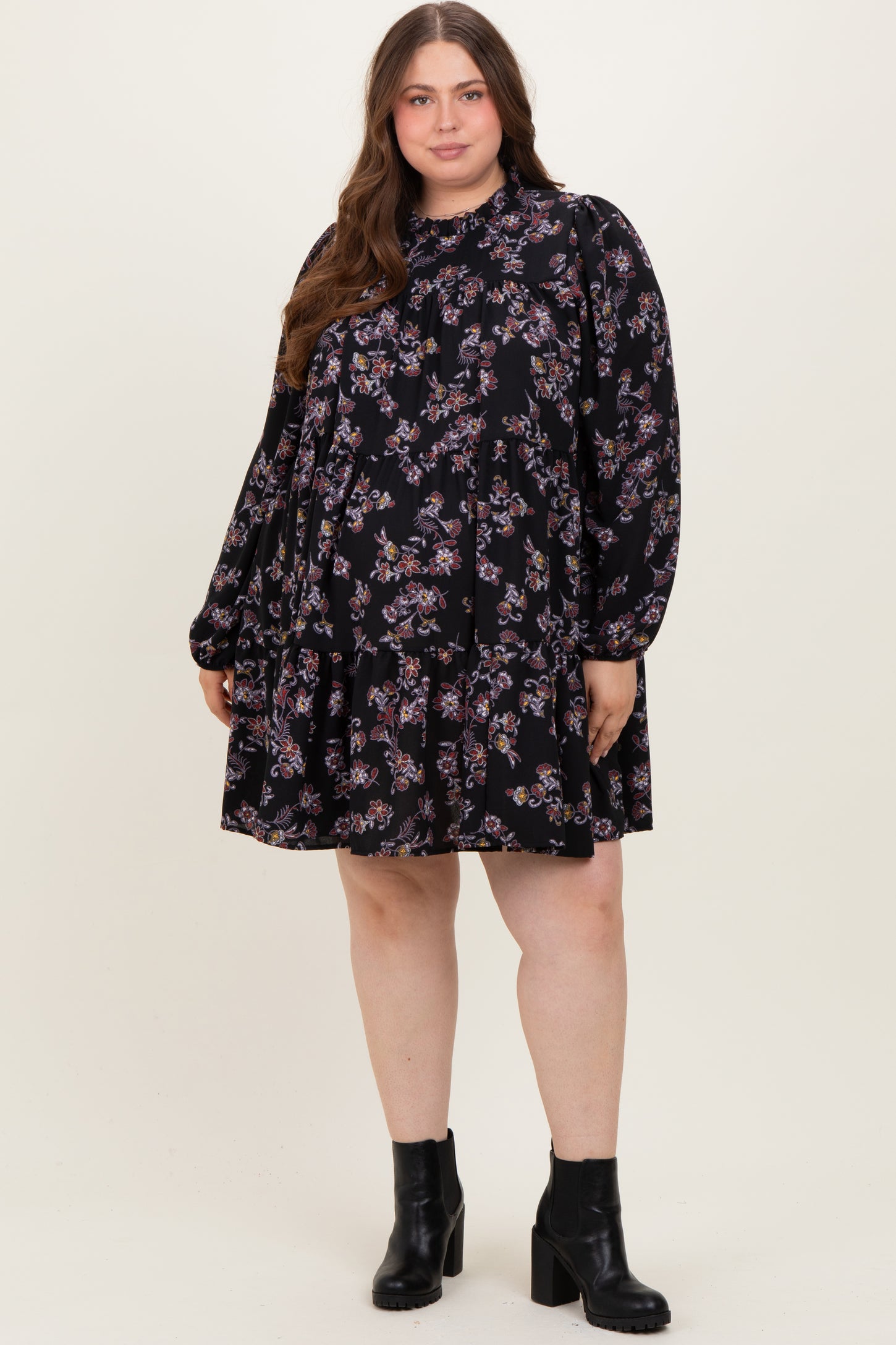 woman wearing a black floral maternity plus dress with long sleeves and a relaxed fit, showcasing a baby bump