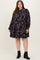 woman wearing a black floral maternity plus dress with long sleeves and a relaxed fit, showcasing a baby bump