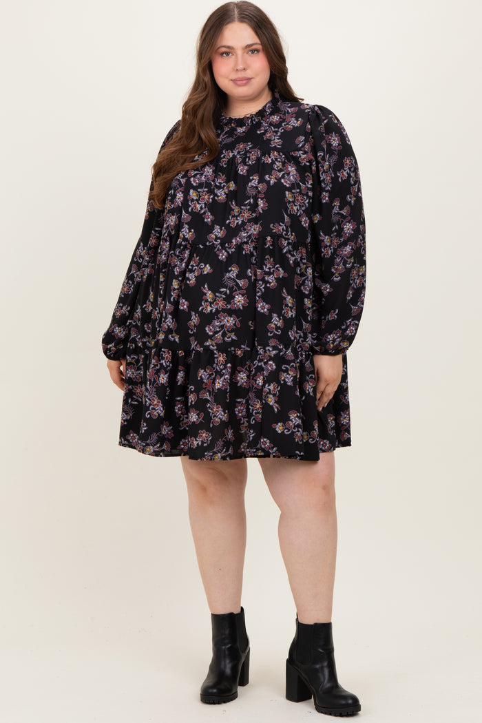 woman wearing a black floral maternity plus dress with long sleeves and a relaxed fit, showcasing a baby bump