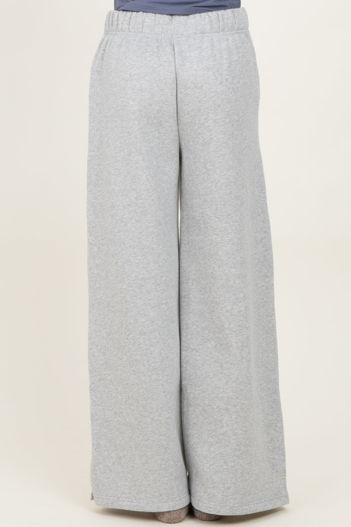 woman wearing light grey wide-leg sweatpants with an elastic waistband, seen from the back