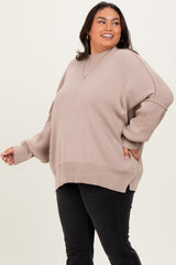 woman wearing a light taupe oversized sweater with long sleeves and a relaxed fit, paired with black jeans