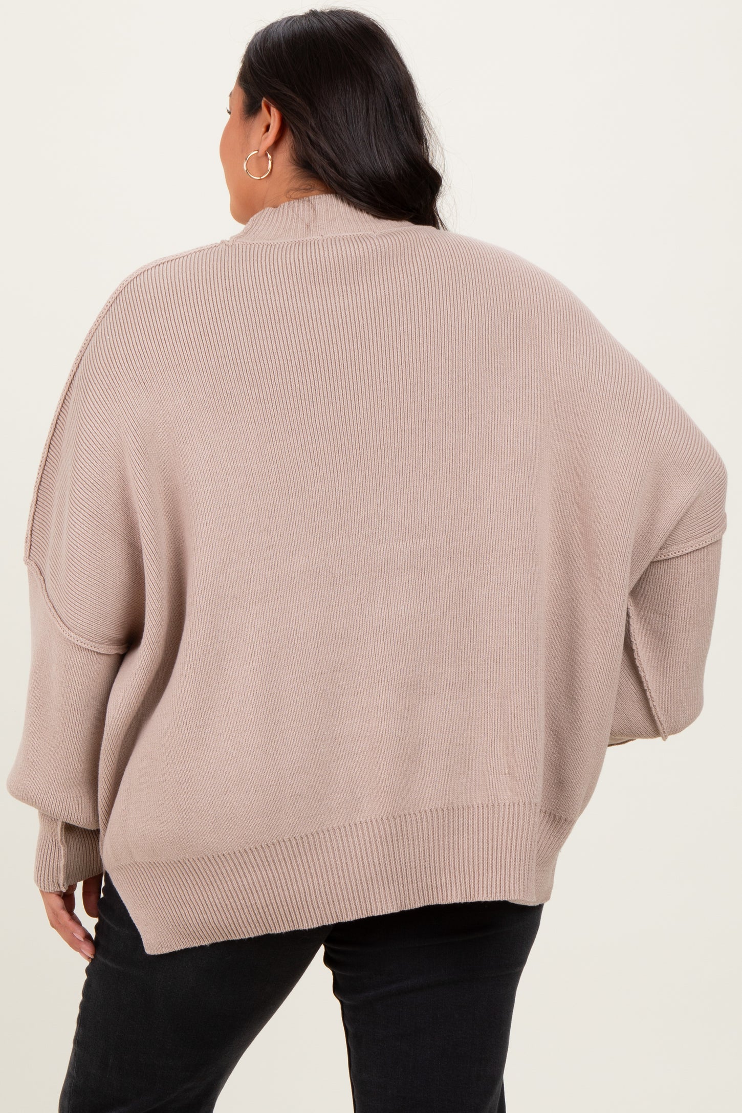 woman wearing a beige oversized sweater with a slouchy fit and dropped shoulder seams