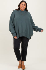 woman wearing a loose-fitting teal turtleneck sweater paired with black jeans and brown slip-on shoes