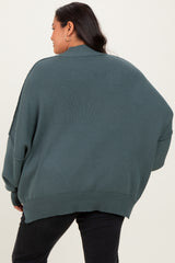 woman wearing a green oversized ribbed sweater, seen from the back, with relaxed fit and dropped shoulders