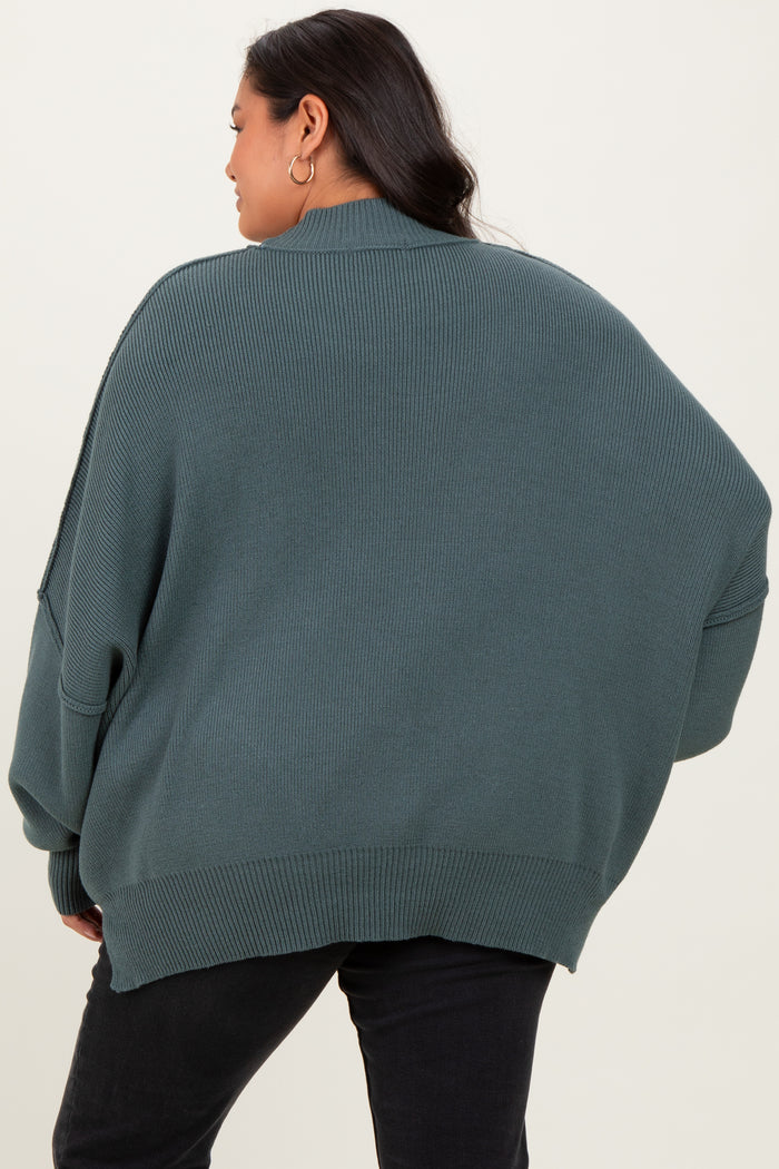 woman wearing a green oversized ribbed sweater, seen from the back, with relaxed fit and dropped shoulders
