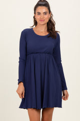 woman wearing a navy long sleeve ribbed dress with a fitted bodice and flared skirt