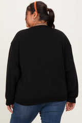 woman wearing a black oversized sweatshirt, viewed from the back, paired with blue jeans