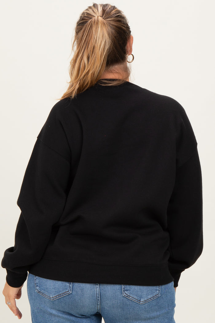 woman wearing a black oversized maternity sweatshirt from the back with long sleeves and relaxed fit