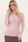 woman wearing a light mauve long sleeve henley top with button details and styled with glasses