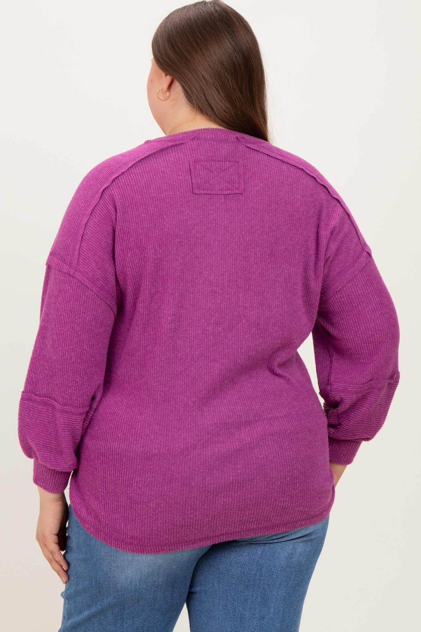 woman wearing a purple ribbed maternity plus top, showing the back with a relaxed fit and slightly puffed sleeves