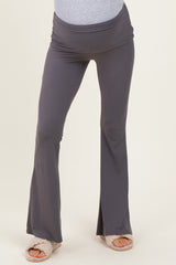 woman wearing gray maternity flared pants with a comfortable waistband and a visible baby bump