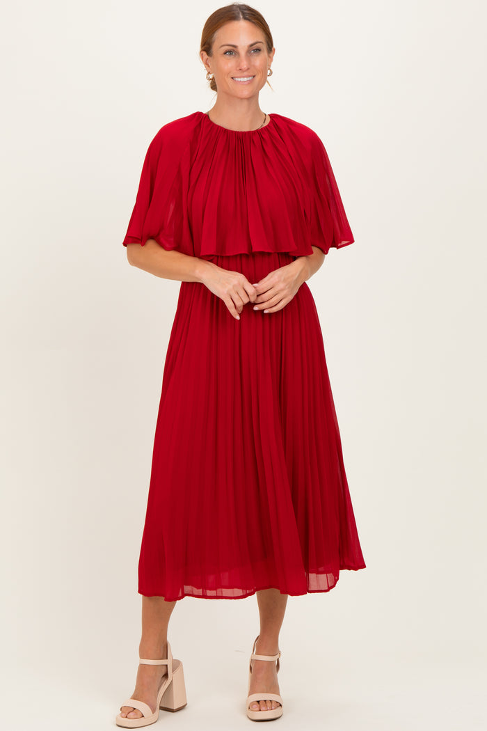 woman wearing a red pleated midi dress with a layered cape sleeve detail