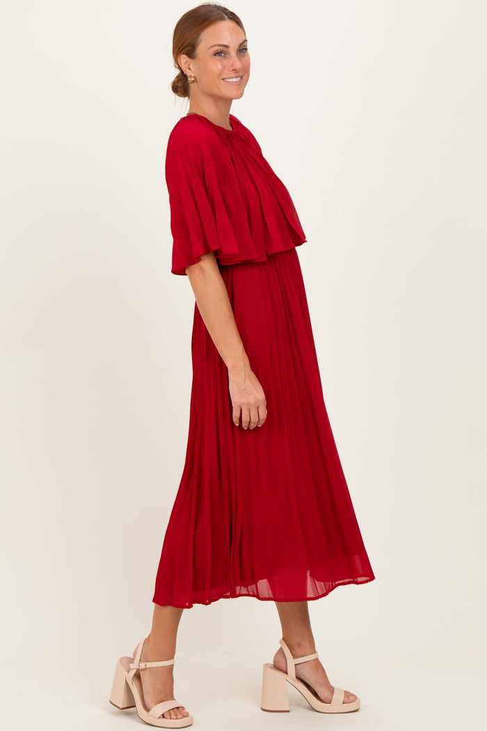 woman wearing a red pleated midi dress with flutter sleeves and a keyhole neck detail, styled with beige block heel sandals